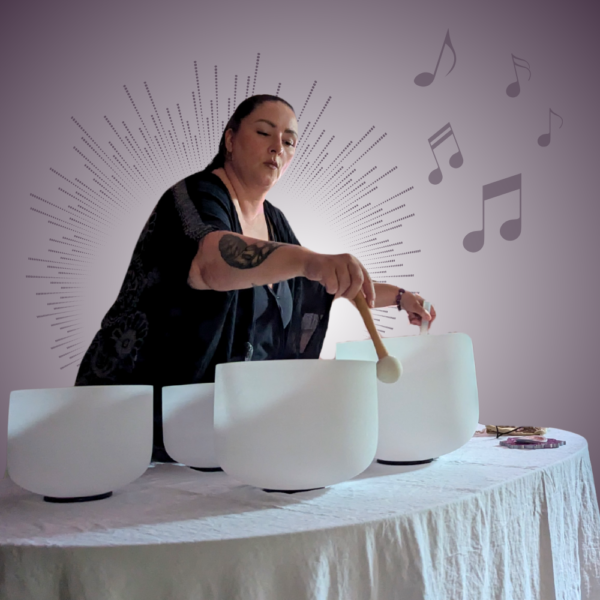 woman playing crystal bowls for sound bath event