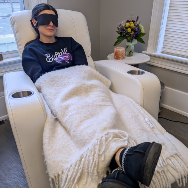 girl relaxing in recliner chair with eye mask and blanket